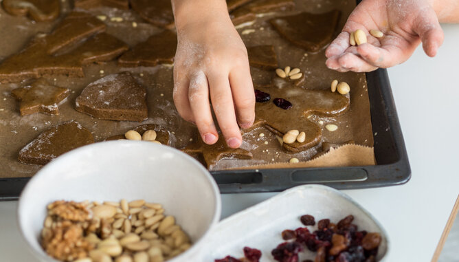 Backen mit Kindern Lebkuchen | © SONNENTOR Auf dem Foto sieht man wie ein Kind ein Lebkuchenmännchen dekoriert. | © SONNENTOR
